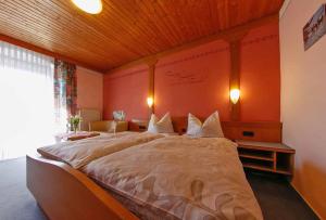 a bedroom with a large bed with a wooden ceiling at Gasthof-Metzgerei-Pension Schierlitz in Rimbach
