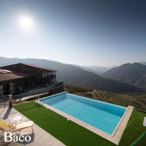 a swimming pool in front of a house with mountains at Terraços de Baco in Ribalonga