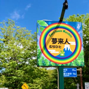 a sign for a mountainmitemitemite sign on a street at Guesthouse Murabito in Yamanakako