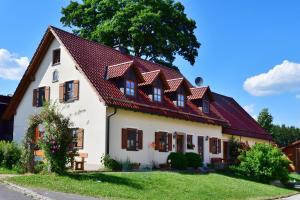 een wit huis met een rood dak bij Ferienwohnung Burgerhof in Pullenreuth