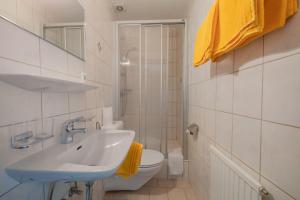uma casa de banho branca com um lavatório e um WC em Gästehaus Danler em Neustift im Stubaital