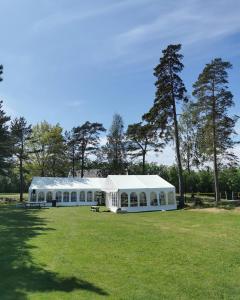 ein großes weißes Zelt auf einem Feld mit Bäumen in der Unterkunft BiG Bed & Breakfast in Grimstad