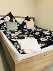 ein Bett mit einer schwarzen und weißen Decke und Kissen in der Unterkunft Noblesse Hause in Gammertingen