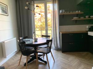 une table et des chaises dans une cuisine avec une fenêtre dans l'établissement Gdańsk Old Town - Elegant Apartment, à Gdańsk