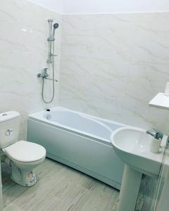 a bathroom with a toilet and a tub and a sink at Studio Katerina in Mamaia