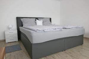 a bed in a bedroom with a white wall at Ferienwohnung Wandl in Bad Griesbach +27 photos