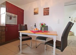 a kitchen with a wooden table with chairs and a dining room at Ferienwohnung Wandl in Bad Griesbach