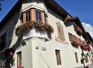 a white building with flowers in a window at Sterzingerhof in Vipiteno