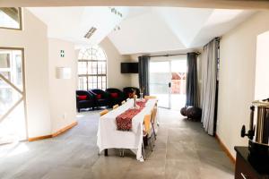 a dining room with a long table and chairs at APS Guesthouse in Windhoek