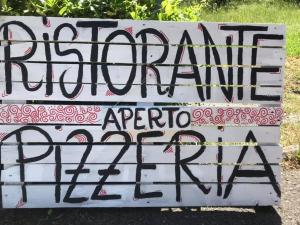 a sign for a music festival with graffiti on it at Hotel Il Poggetto in Castellina Marittima