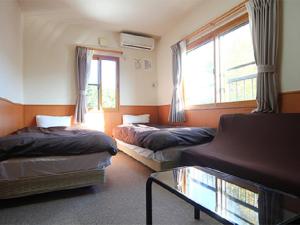 En eller flere senger på et rom på Karuizawamura Hotel
