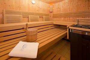 a wooden sauna with a bucket and a napkin in it at Panoramahotel in Sankt Johann in Tirol