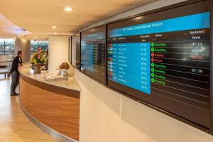 a waiting area in a hotel lobby with a large screen at City Lodge Hotel at OR Tambo International Airport in Kempton Park