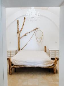 - une chambre avec un lit et une branche d'arbre sur le mur dans l'établissement La Casita Blanca casa vacanze, à Bisceglie