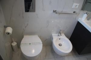 a white toilet sitting next to a white sink at B&B Pescara Centro Luxury Suite in Pescara