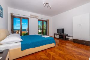 a large bedroom with a bed and a television at Apartmani Pilaš in Dramalj