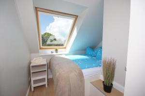 um pequeno quarto com uma cama e uma janela em Ferienwohnung Krähenberg em Grömitz