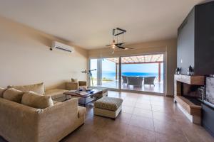 un salon avec un canapé et une table dans l'établissement Blue Horizon Villas with Private Pool & Sea View, à Plateies