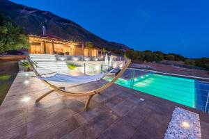 una hamaca en un patio junto a una piscina en Blue Horizon Villas with Private Pool & Sea View, en Plateies