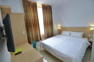 - une chambre avec un lit et une télévision dans l'établissement T-ONE HOTEL, à Tanjungjohor