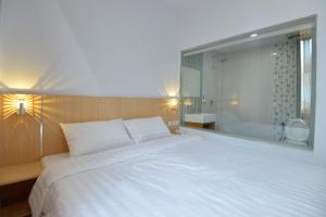 um quarto com uma grande cama branca e uma janela em T-ONE HOTEL em Tanjungjohor