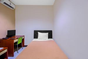 Cama en habitación con escritorio y cama sidx sidx sidx sidx en Griya Stadion, en Semarang