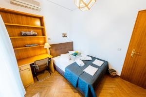 a small bedroom with a bed and a desk at Xenia in Iraklitsa