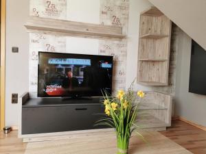 uma sala de estar com uma televisão de ecrã plano na parede em Privatzimmer Guhl em Munster im Heidekreis