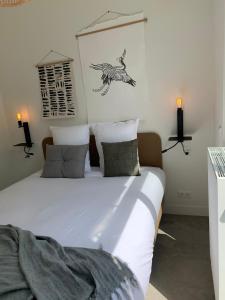 a bedroom with a large white bed with a bird on the wall at Utrecht City Apartments - Maliesingel in Utrecht
