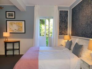 een slaapkamer met een groot bed en een raam bij Boutique Hotel Villa de Proosdij in Klimmen