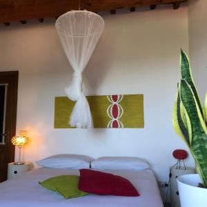 sypialnia z białym łóżkiem z zasłoną w obiekcie Anitta GuestHouse w mieście Castagneto Carducci