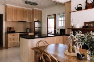 cocina con armarios de madera y mesa de madera en Ned Kelly’s Marlo Cottage - in the best Beechworth location, en Beechworth