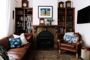 a living room with a couch and a fireplace at Ned Kelly’s Marlo Cottage - in the best Beechworth location in Beechworth