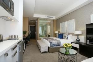 a hotel room with a bed and a kitchen at 304 Sandton Skye in Johannesburg