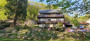 een groot huis met een balkon en een tuin bij Gästehaus Gerhardt in Schweigen-Rechtenbach