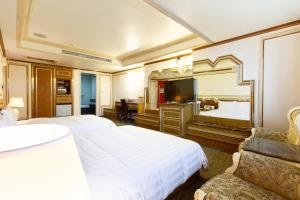 Cette chambre comprend 2 lits et un miroir. dans l'établissement Baron's Hot Spring Hotel, à Jiaoxi