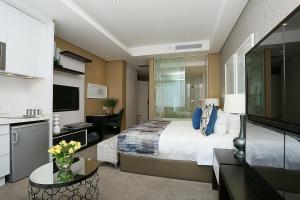 1 dormitorio con 1 cama grande y cocina en 304 Sandton Skye, en Johannesburgo