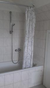 a bathroom with a shower and a white shower curtain at Království klidu in Prachatice