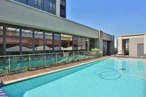 una grande piscina di fronte a un edificio di 304 Sandton Skye a Johannesburg