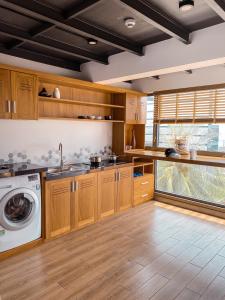 a kitchen with wooden cabinets and a washing machine at Coast House Boutique Hotel in Nha Trang