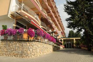 ein Gebäude mit lila Blumen an einer Steinmauer in der Unterkunft Hotel Belvedere in Ohrid