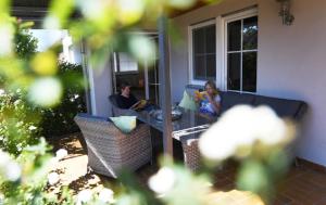 two people sitting on a porch reading books at Ferienbauernhof Schuler in Gunzenhausen
