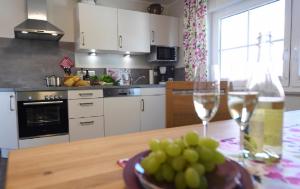a kitchen with a table with wine glasses and a bowl of grapes at Ferienbauernhof Schuler in Gunzenhausen