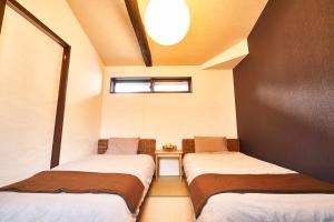 京都市にある北野天満宮 邸宅 the HOUSEのベッド2台とテーブルがある小さな部屋
