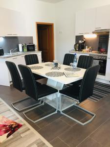a white table with black chairs in a kitchen at Ferienwohnung Marina an der Romantischen Straße in Weikersheim
