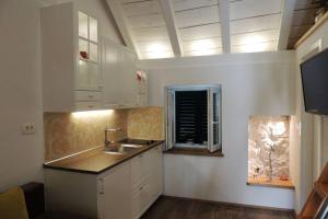 eine Küche mit weißen Schränken und einer Spüle und einem Fenster in der Unterkunft Romantic Apartment in Center in Split + 37 Fotos