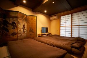 a bedroom with a bed and a television in it at Kitano Tenmangu The House in Kyoto