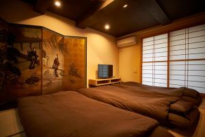 京都市にある北野天満宮 邸宅 the HOUSEのベッドとテレビのある寝室