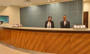 two people standing at a counter in a lobby at City Lodge Hotel Fourways in Johannesburg