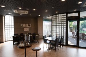 - une salle à manger avec une table, des chaises et des fenêtres dans l'établissement Hotel Arashiyama, à Kyoto